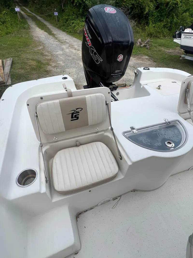 Slide: The Image of 2015 Carolina Skiff 218 DLV boat with outboard motor and seating area. - 8