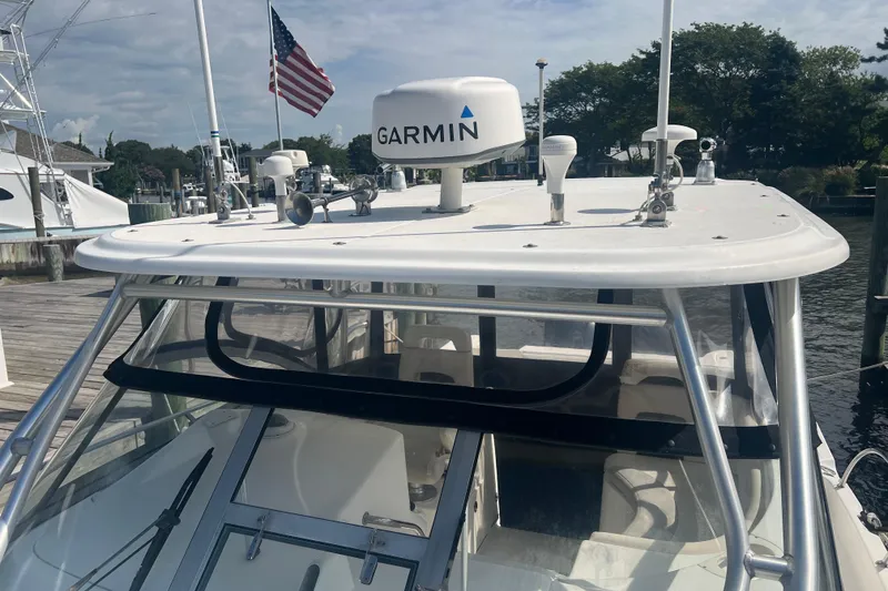 Slide: The Image of 2004 Boston Whaler 305 Conquest with Garmin radar, docked near American flag. - 10