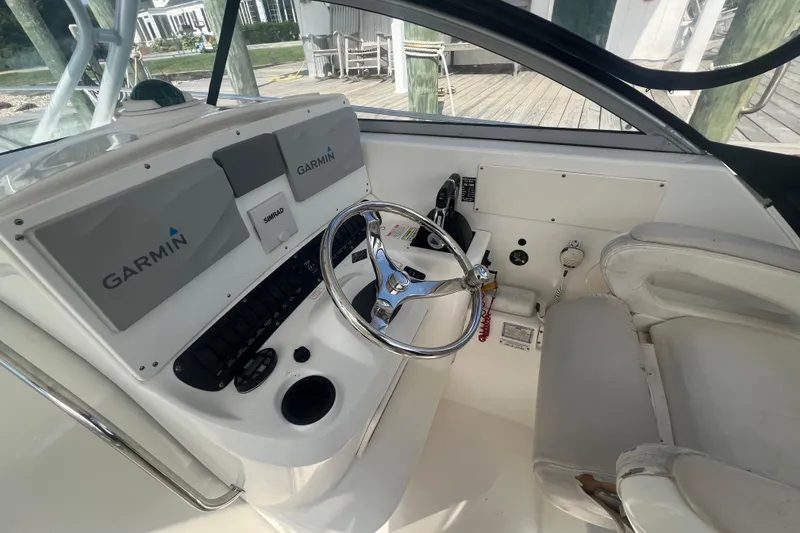 Slide: The Image of 2004 Boston Whaler 305 Conquest helm with Garmin navigation and steering wheel. - 13