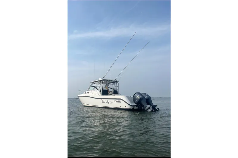 Slide: The Image of 2004 Boston Whaler 305 Conquest boat on calm water under clear sky. - 14