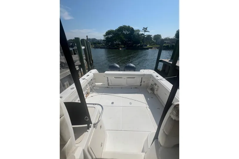 Slide: The Image of 2004 Boston Whaler 305 Conquest boat docked by a scenic waterfront. - 20