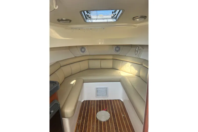 Slide: The Image of Interior cabin of 2004 Boston Whaler 305 Conquest with beige seating and wood flooring. - 21