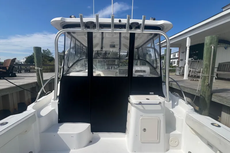 Slide: The Image of 2004 Boston Whaler 305 Conquest boat docked, showcasing cockpit and cabin entrance. - 3
