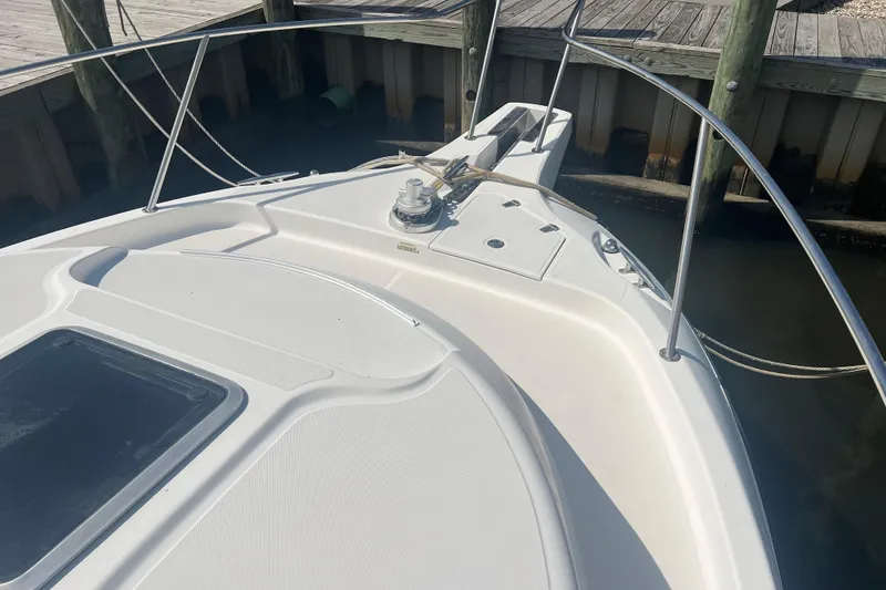 Slide: The Image of Bow of 2004 Boston Whaler 305 Conquest docked, featuring sleek design and sturdy railings. - 9