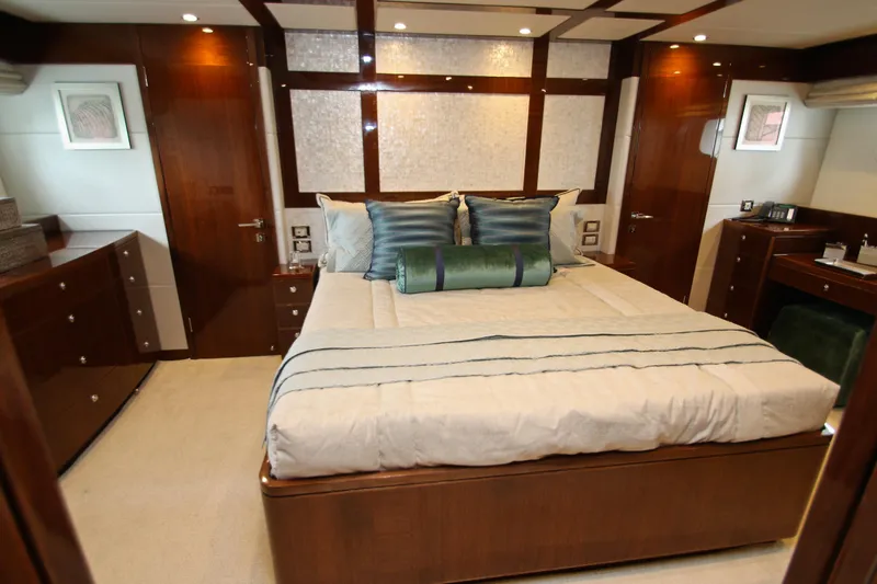 Slide: The Image of Luxurious bedroom interior on 2015 Hargrave 76 yacht, featuring elegant wood finishes and plush bedding. - 58