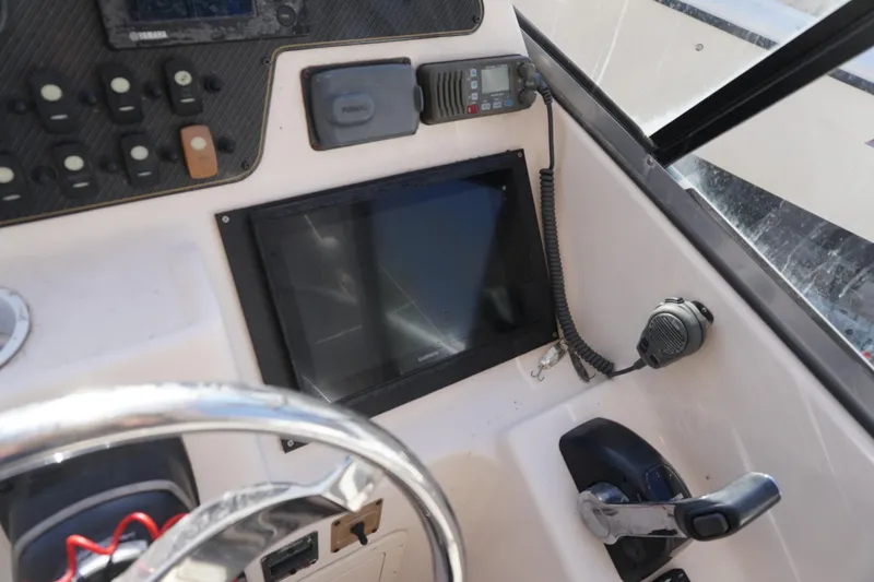 Slide: The Image of Control panel of 2011 Grady-White Freedom 255 boat with steering wheel and navigation equipment. - 11