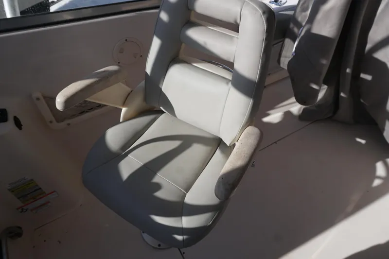 Slide: The Image of Captain's chair on 2011 Grady-White Freedom 255 boat, featuring cushioned armrests and sleek design. - 14