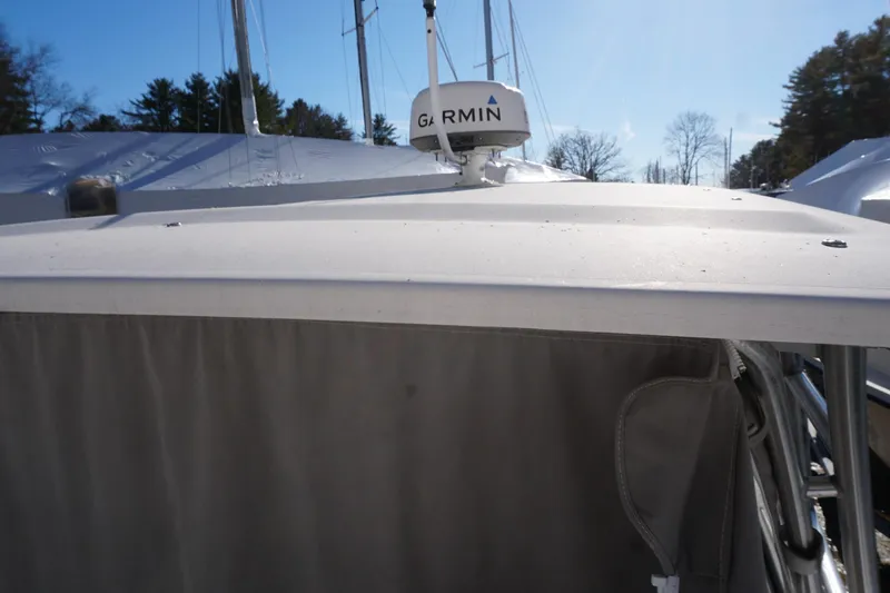 Slide: The Image of 2011 Grady-White Freedom 255 boat with Garmin radar, docked under clear sky. - 18