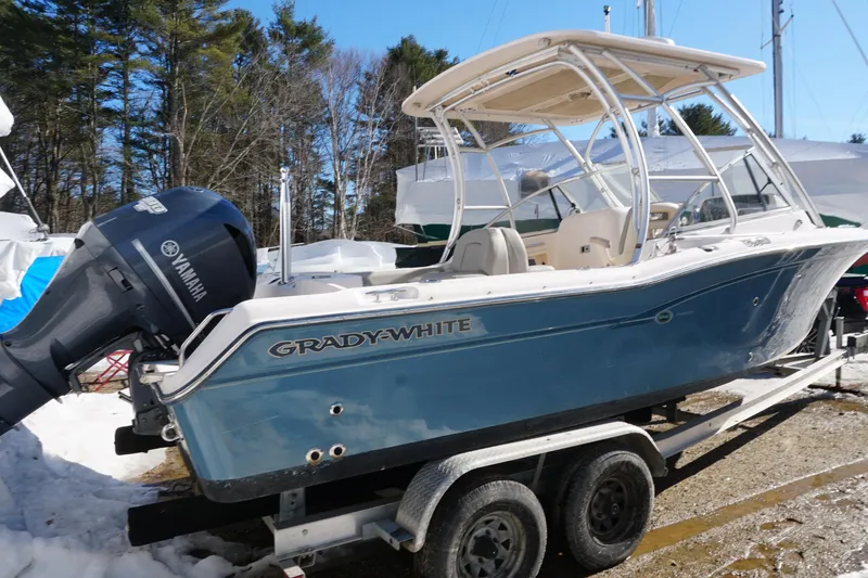 Slide: The Image of 2011 Grady-White Freedom 255 boat on trailer with Yamaha engine, parked outdoors. - 2