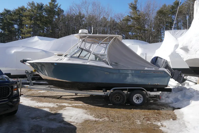 Slide: The Image of 2011 Grady-White Freedom 255 boat on trailer, parked in snowy outdoor setting. - 22