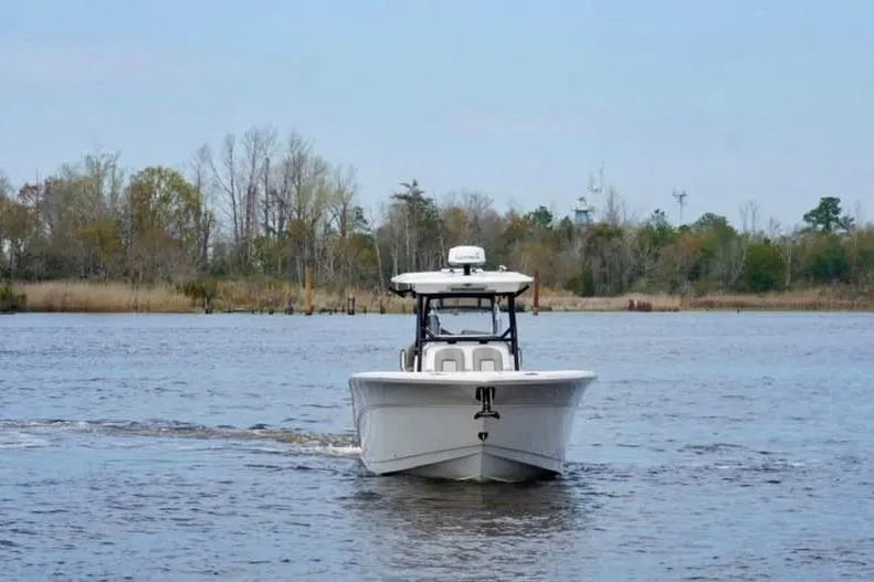 Slide: The Image of 2023 Sea Fox 328 Commander boat cruising on a calm river with trees in the background. - 3