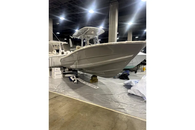 Slide: The Image of 2024 Bulls Bay 255 Center Console boat displayed indoors at a showroom. - 2