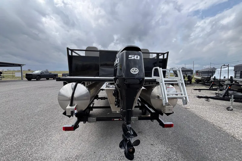 Slide: The Image of 2026 Dockside 20DF pontoon boat with outboard motor and ladder, parked outdoors. - 3