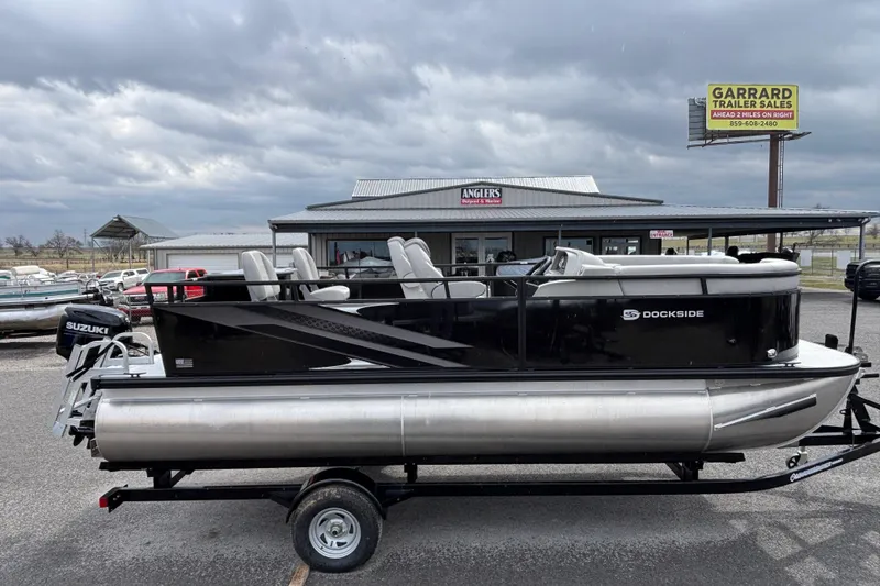 Slide: The Image of 2026 Dockside 20DF pontoon boat on trailer, parked at dealership under cloudy sky. - 4