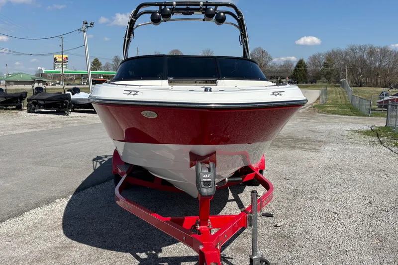 Slide: The Image of 2021 Monterey M-22 boat on a red trailer, parked outdoors on a sunny day. - 2