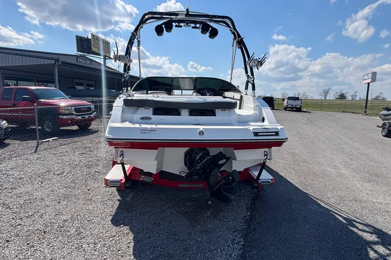 Slide: The Image of 2021 Monterey M-22 boat, rear view, parked outdoors under a clear blue sky. - 4