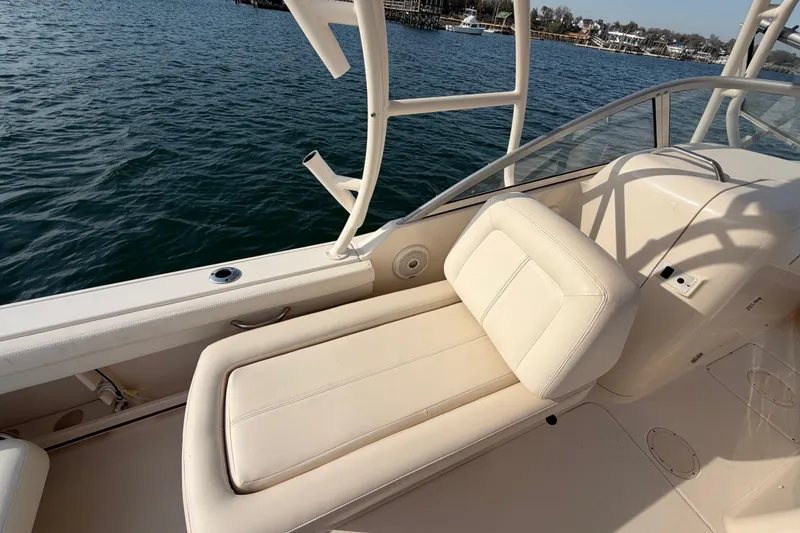 Slide: The Image of 2017 Grady-White Freedom 225 boat interior with beige seating, on calm water. - 25