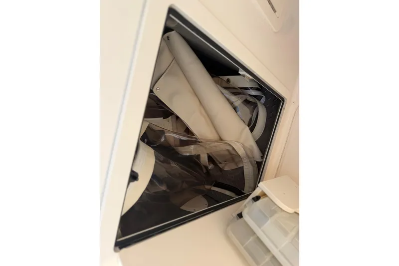 Slide: The Image of Storage compartment on 2017 Grady-White Freedom 225 boat, containing rolled canvas and gear. - 41