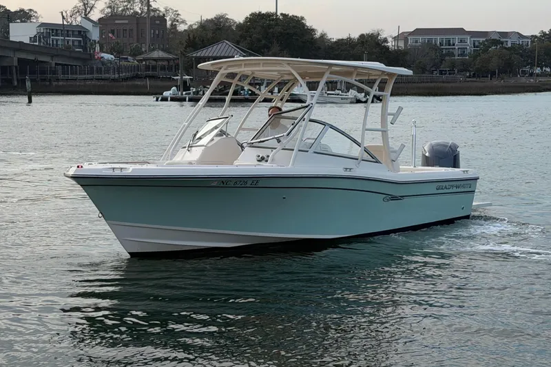 Slide: The Image of 2017 Grady-White Freedom 225 boat cruising on calm water near a marina. - 5