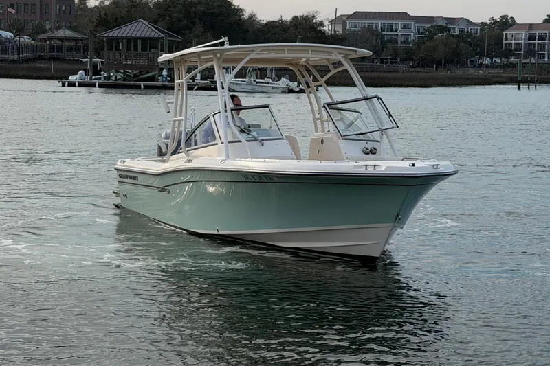 Slide: The Image of 2017 Grady-White Freedom 225 boat cruising on calm water near a marina. - 6