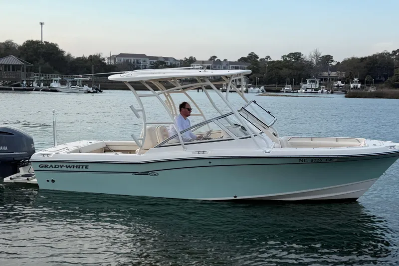 Slide: The Image of 2017 Grady-White Freedom 225 boat on water, side view, with person at helm. - 8