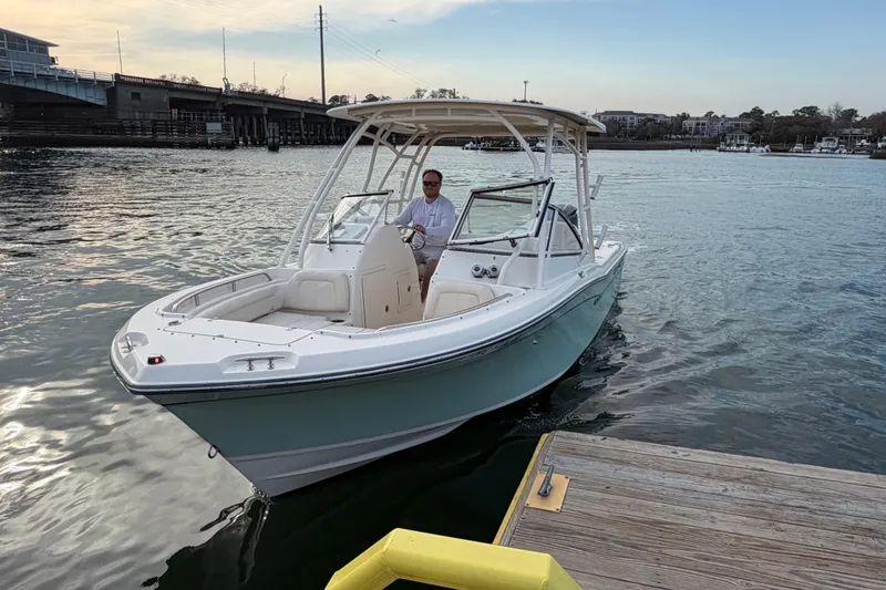 Slide: The Image of 2017 Grady-White Freedom 225 boat docked on calm water, under a clear sky. - 9