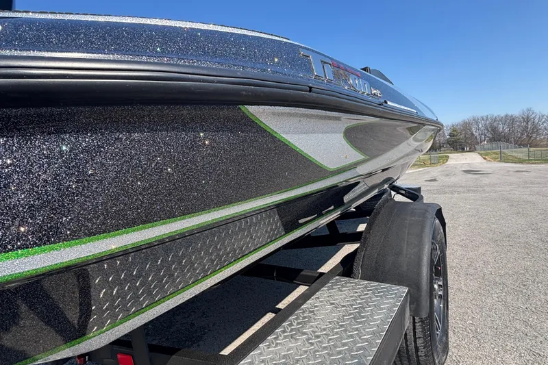 Slide: The Image of 2020 Triton 189 TrX boat with sparkling finish on a trailer, under clear blue sky. - 4