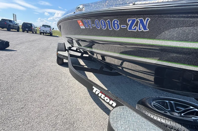 Slide: The Image of 2020 Triton 189 TrX boat on trailer, parked on asphalt with vehicles in background. - 5