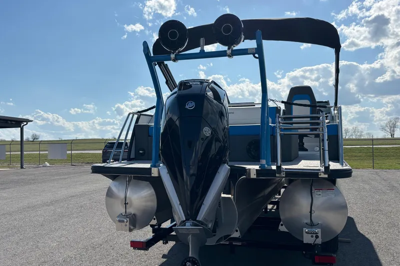 Slide: The Image of 2025 Berkshire 25UL DC STS pontoon boat with powerful outboard motor, parked outdoors. - 2