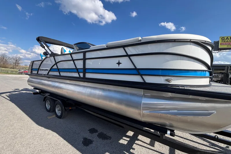 Slide: The Image of 2025 Berkshire 25UL DC STS pontoon boat on trailer under blue sky. - 3