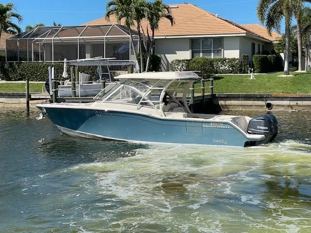 Slide: The Image of 2021 Grady-White 325 Freedom boat on water near coastal home. - 5