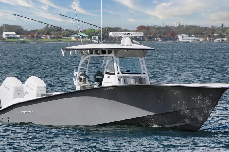 Slide: The Image of 2024 Cape Horn 39 T boat cruising on a scenic waterway with dual Mercury engines. - 3