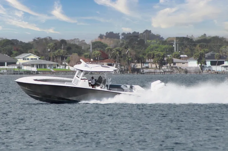 Slide: The Image of 2024 Cape Horn 39 T boat cruising on water near coastal homes. - 32