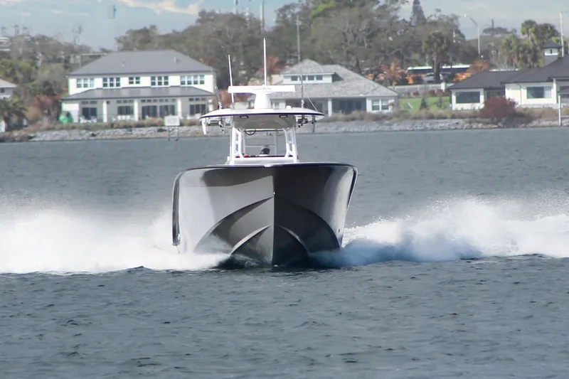 Slide: The Image of 2024 Cape Horn 39 T boat cruising on water with waterfront homes in background. - 34