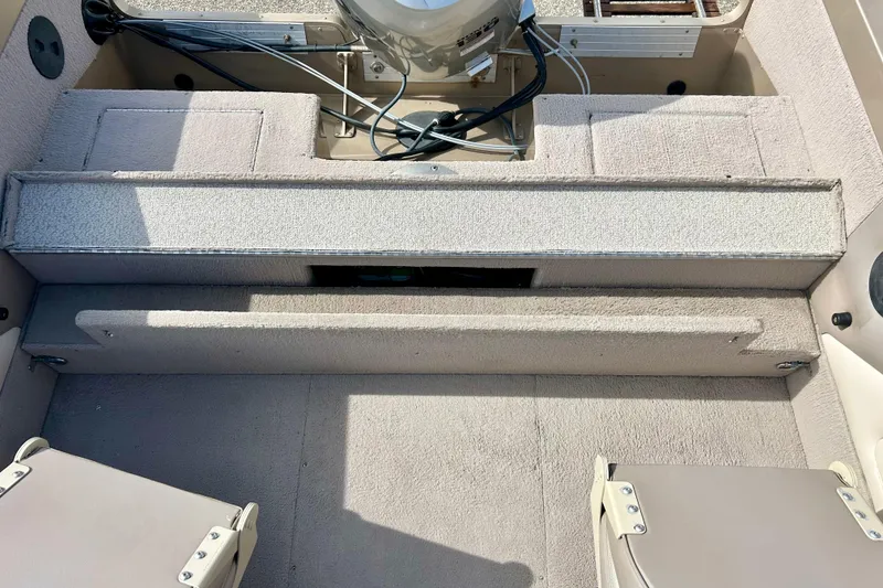 Slide: The Image of Interior view of a 2000 Lund 1850 Tyee Gran Sport boat, showcasing seating and storage. - 26