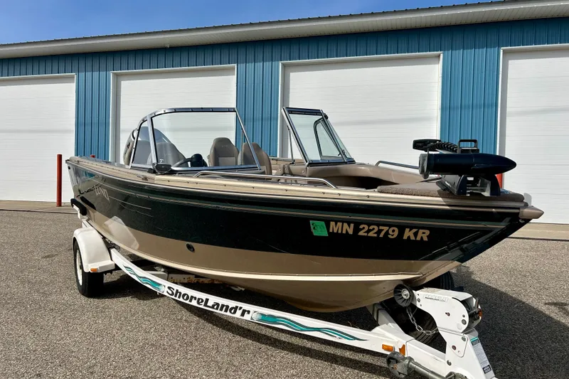 Slide: The Image of 2000 Lund 1850 Tyee Gran Sport boat on trailer in front of blue garage. - 37