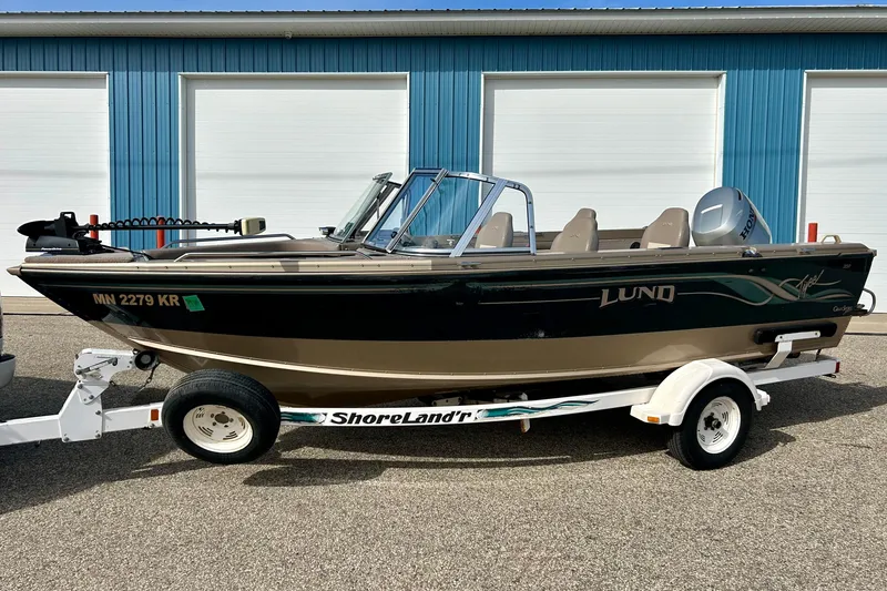 Slide: The Image of 2000 Lund 1850 Tyee Gran Sport boat on trailer in front of blue garage. - 38