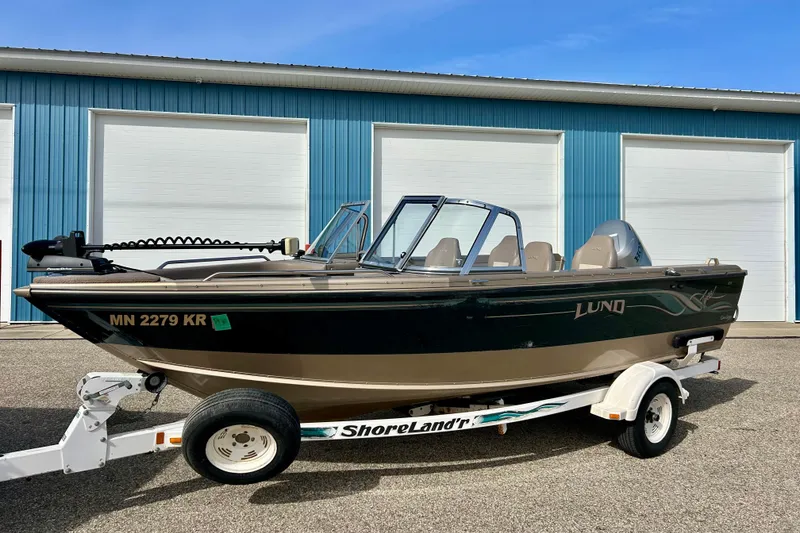 Slide: The Image of 2000 Lund 1850 Tyee Gran Sport boat on trailer in front of blue garage. - 39