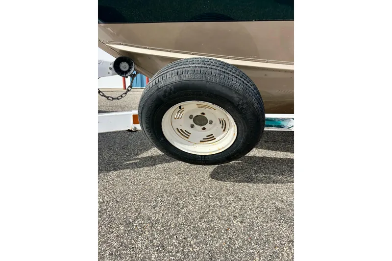 Slide: The Image of Lund 1850 Tyee Gran Sport 2000 boat trailer tire on asphalt. - 43