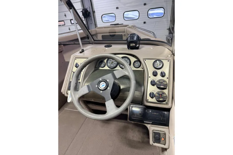 Slide: The Image of 2000 Lund 1850 Tyee Gran Sport boat interior with beige seating and windshield. - 5