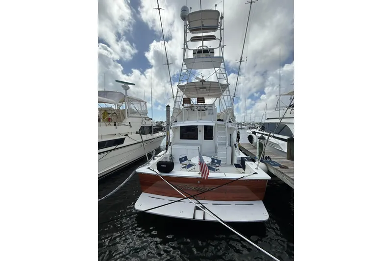 Slide: The Image of 1988 Bertram 43 Flybridge yacht docked at marina under cloudy sky. - 10