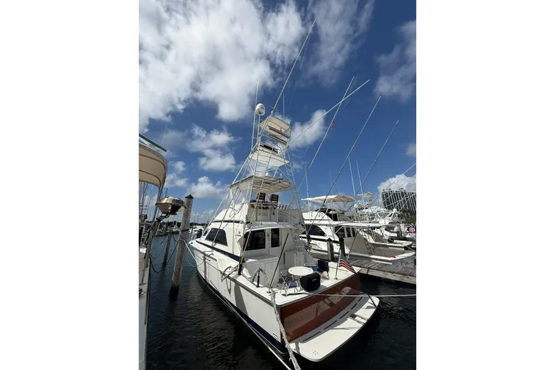 Slide: The Image of 1988 Bertram 43 Flybridge yacht docked under a bright blue sky. - 12