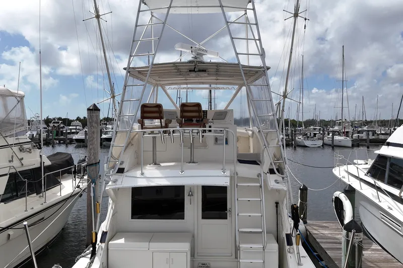 Slide: The Image of 1988 Bertram 43 Flybridge yacht docked at marina under cloudy sky. - 14