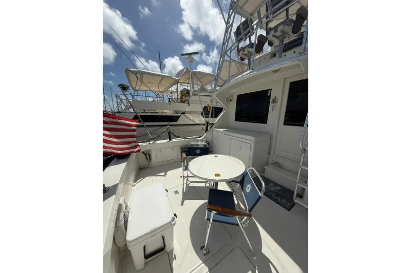 Slide: The Image of 1988 Bertram 43 Flybridge yacht deck with seating and American flag. - 18