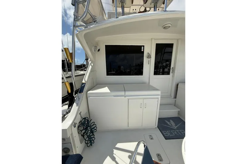 Slide: The Image of 1988 Bertram 43 Flybridge boat deck with storage and door, featuring nautical elements. - 21