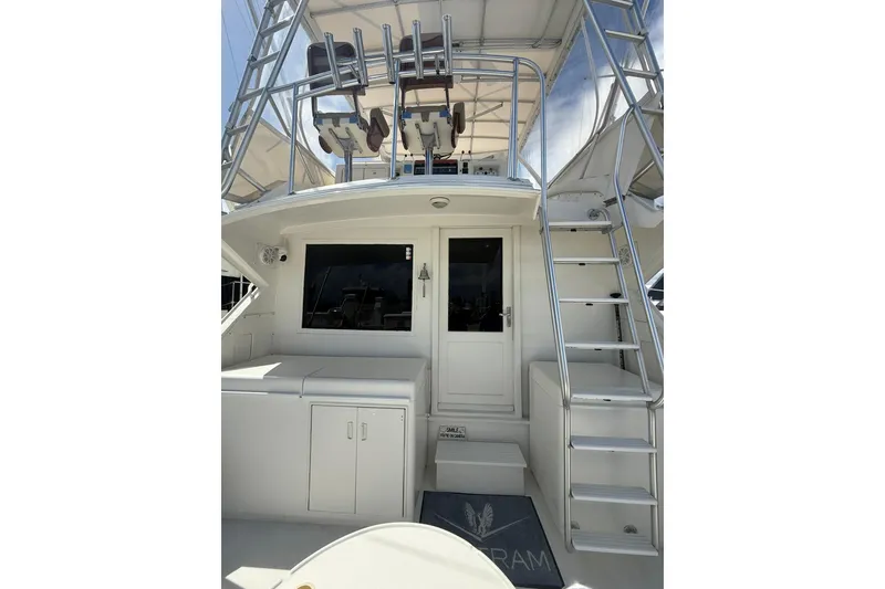 Slide: The Image of 1988 Bertram 43 Flybridge yacht with ladder and seating area, showcasing sleek design. - 24
