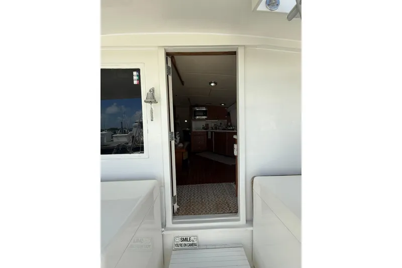 Slide: The Image of 1988 Bertram 43 Flybridge yacht interior view through open door, showcasing cabin area. - 25