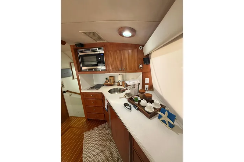 Slide: The Image of Interior of 1988 Bertram 43 Flybridge yacht kitchen with wooden cabinetry and modern appliances. - 34