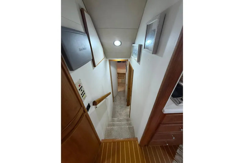 Slide: The Image of Interior hallway of 1988 Bertram 43 Flybridge yacht, featuring stairs and wooden accents. - 43