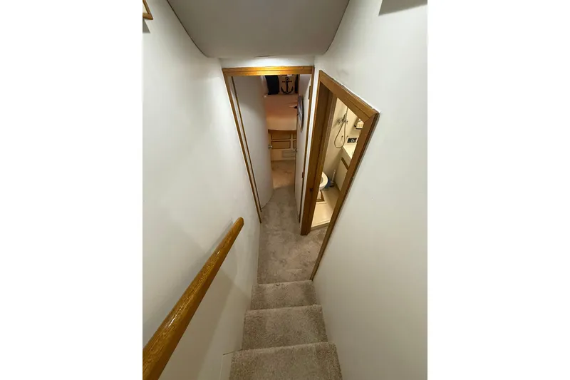 Slide: The Image of Stairway inside 1988 Bertram 43 Flybridge yacht, leading to cabin and bathroom. - 44